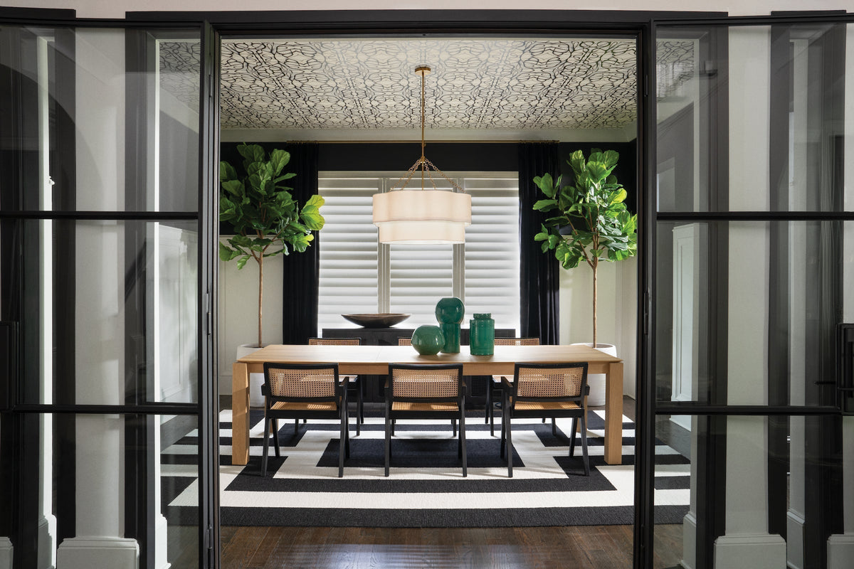 Brass drum chandelier with white linen shade in modern black and white dining room