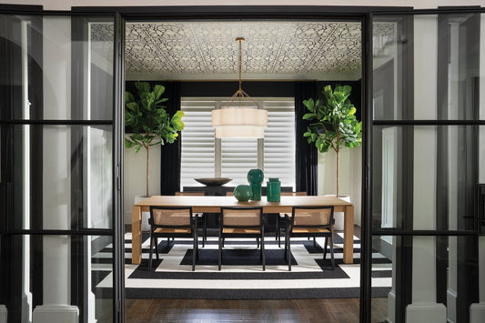 Brass drum chandelier with white linen shade in modern black and white dining room