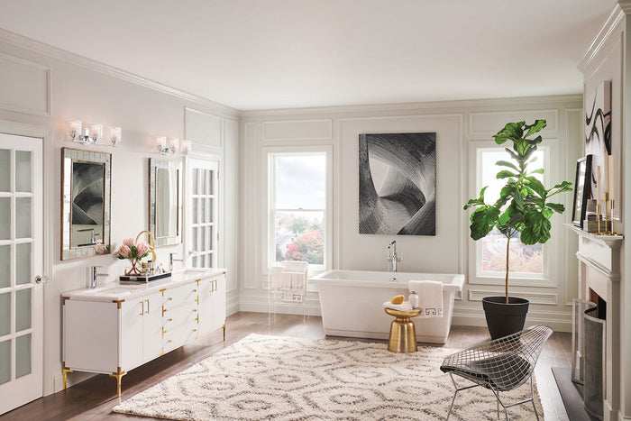Hinkley Elle 24-inch chrome 3-light vanity with clear chevron-cut glass shades above a white and gold dual vanity in a glam primary bathroom