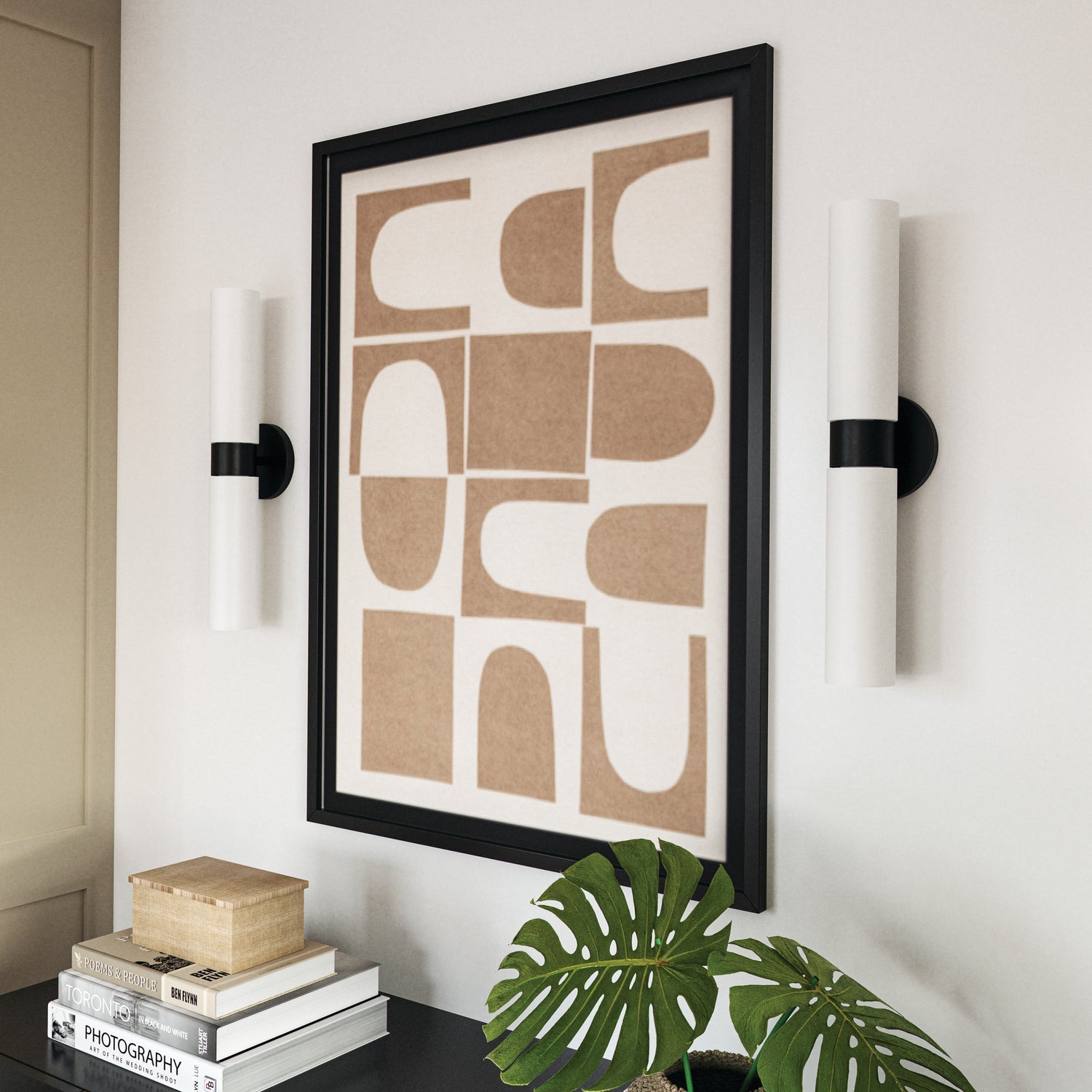 Two Theo wall sconces flanking a contemporary artwork above a console table.