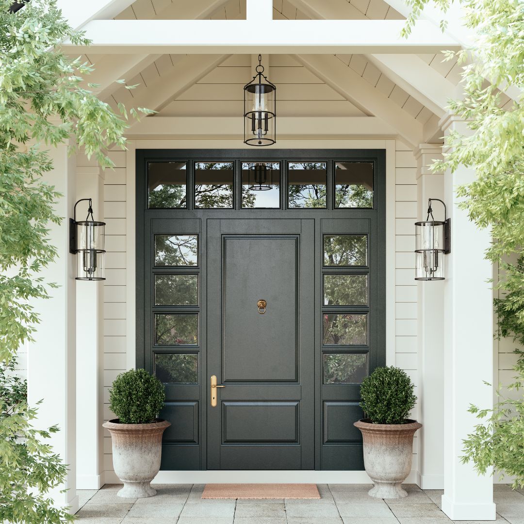 An entryway featuring Burbank Wall Sconces flanking a black traditional door, with a Burbank Pendant centered above, complemented by greenery against ivory walls.