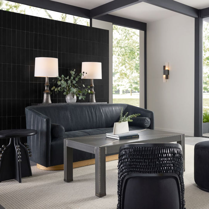 Huxley Sofa in Noir Leather White Oyster styled within a contemporary sitting room, accompanied by a coffee table and side table, with a console table behind featuring matching lamps and a touch of greenery.