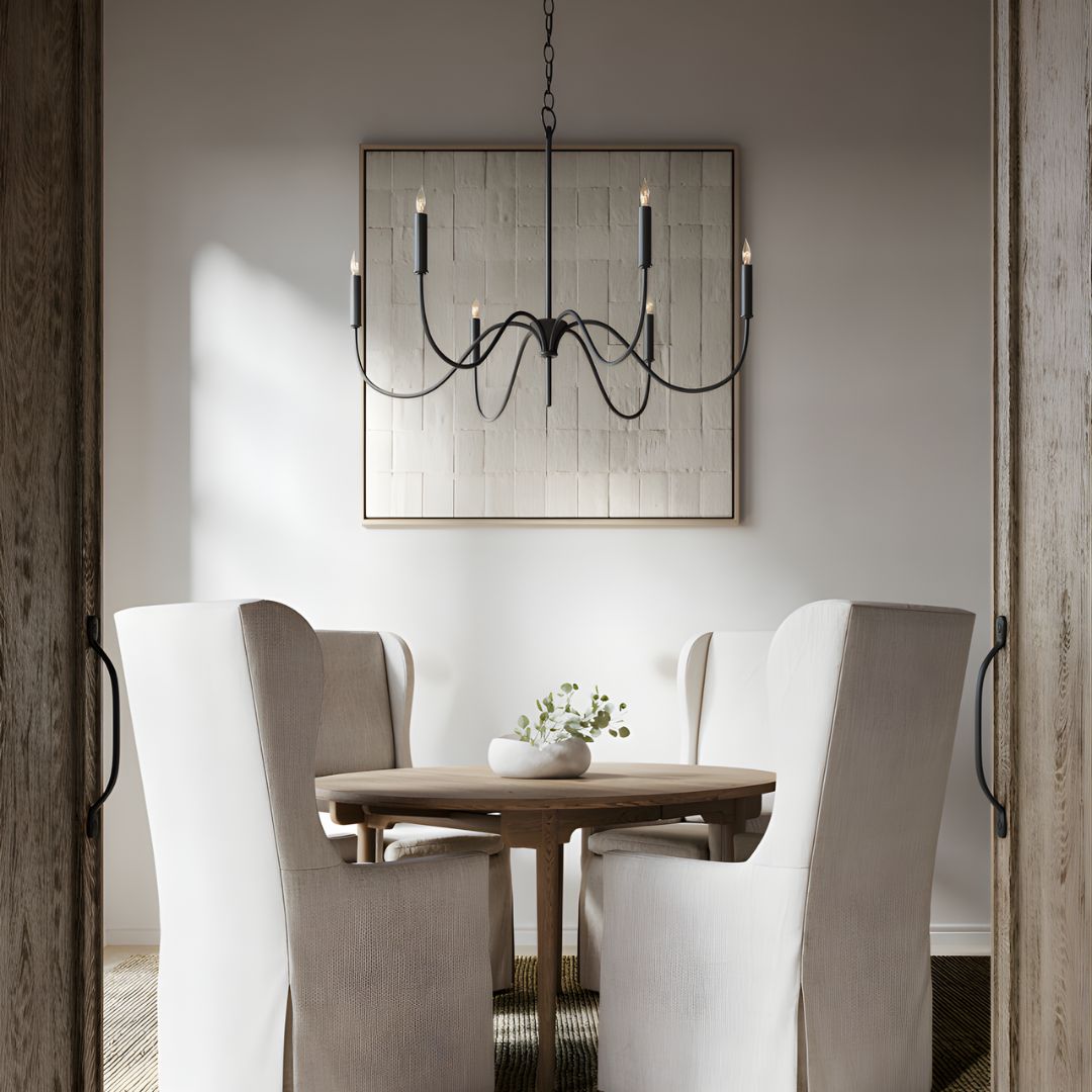 Tirrell Small Black Chandelier centered in a contemporary dining room, suspended above a round brown table surrounded by four transitional dining chairs.