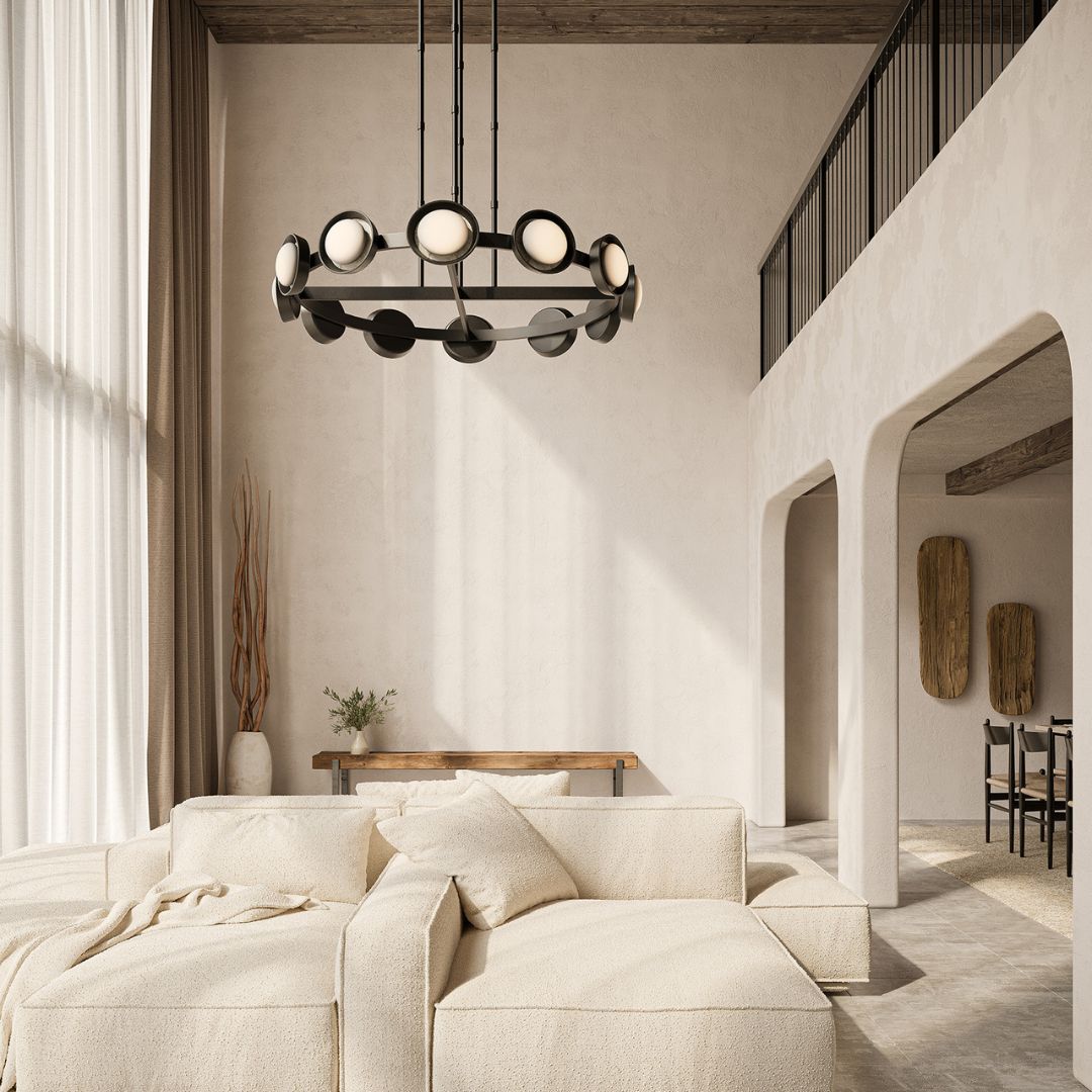 Alonso chandelier suspended in a warm, modern living space with a curved ivory sofa, textured neutral finishes, wood beam ceiling, and arched architectural details.