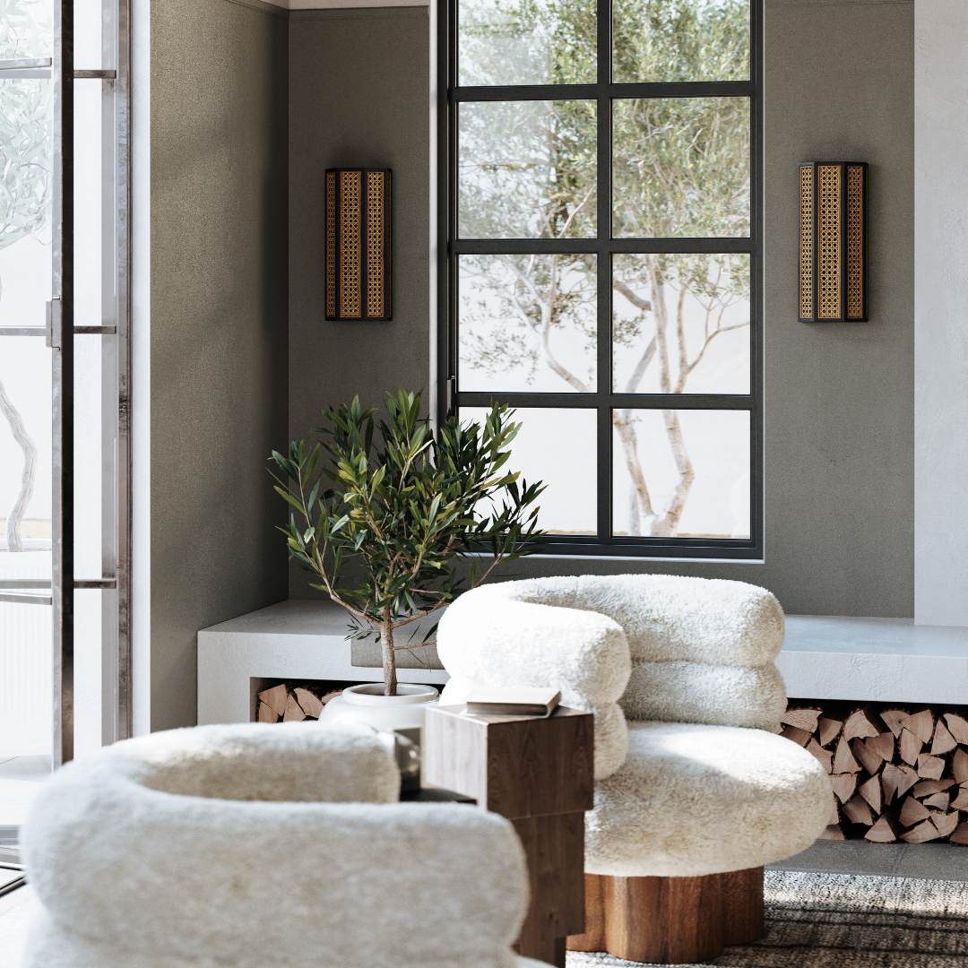 A pair of Englewood Adjustable Wall Sconces with Plug styled in a sitting room, mounted on a dark green wall flanking a window.