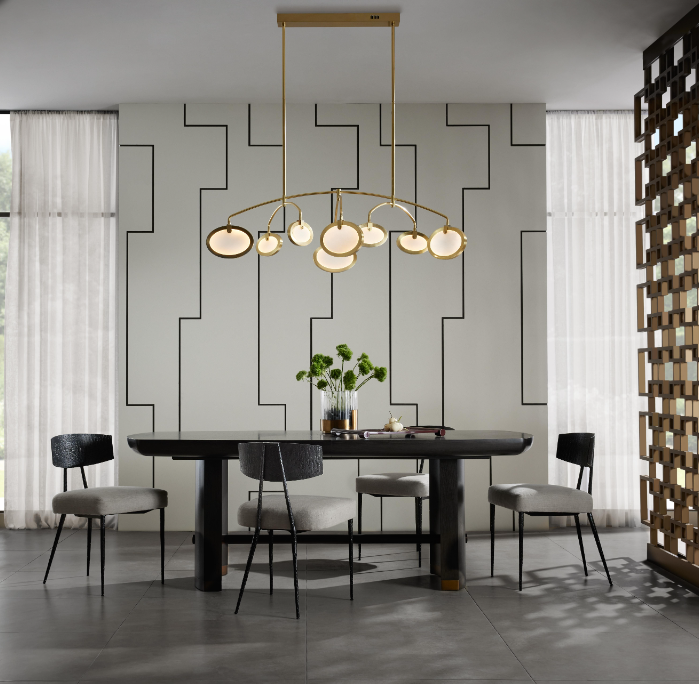 Rosabel Chandelier positioned in the center of a contemporary dining room, suspended above a dark wood table surrounded by four chairs.