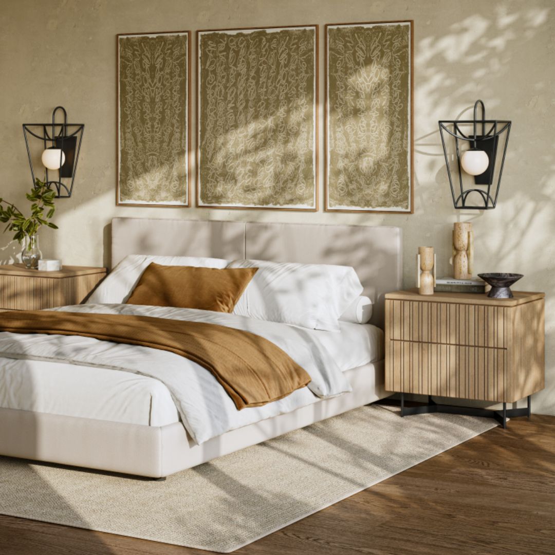 Rochefort Small Wall Sconce paired with an Indeo Washed Oak Nightstand, styled in a contemporary bedroom with three framed artworks displayed above the bed.