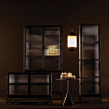Noir Chandler 2 Door Sideboard Matte Black with fluted glass doors, at left in a dark room with taller matching cabinets and a lit pendant