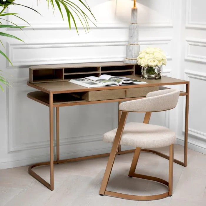 Wooden desk with chair in a home office space with white walls and decorative elements.