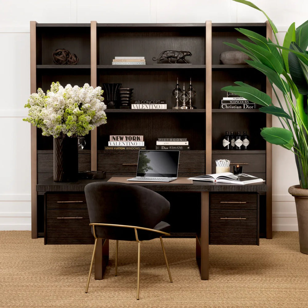 Luxurious wooden office desk with bookshelf, chair, and decorative items in a home office setting.