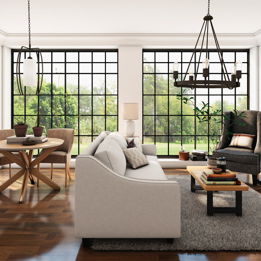 Farmhouse living room with large windows, gray sofa, and wooden furniture.