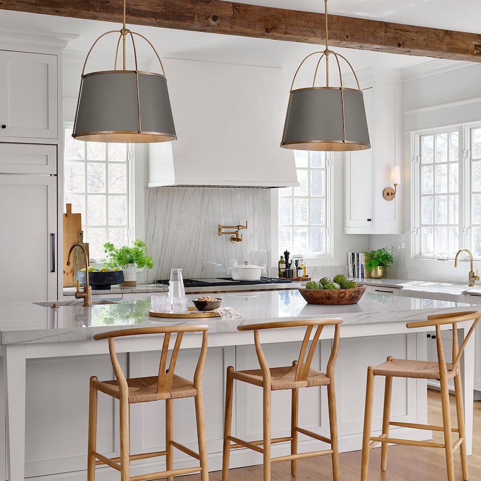 Modern kitchen with white island, wooden bar stools, and two Clarke pendant lights by Hinkley.