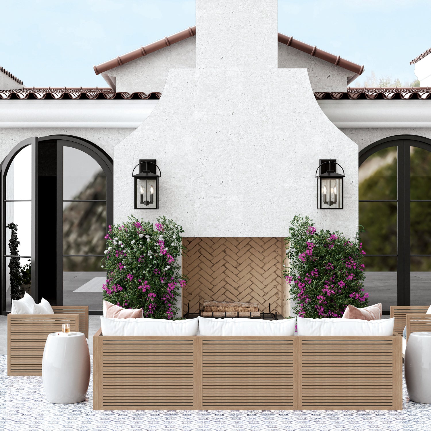 Outdoor patio area with wooden furniture, white cushions, and potted plants in front of a white building.