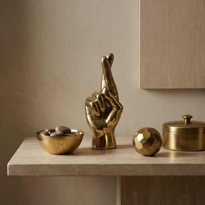Noir Fingers Crossed Sculpture Antique Brass styled in an interior setting