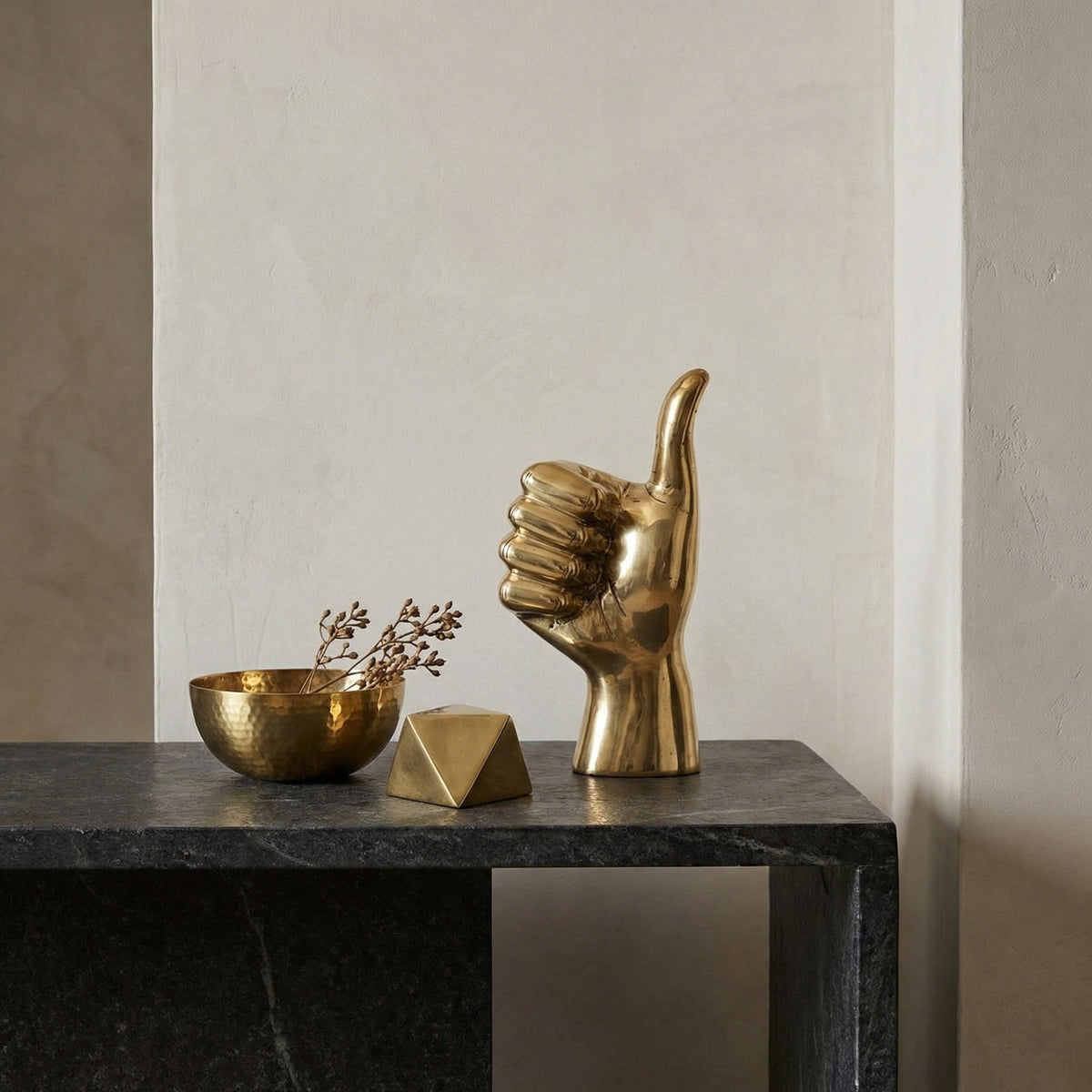 Noir Thumbs Up Sculpture Antique Brass styled in an interior setting
