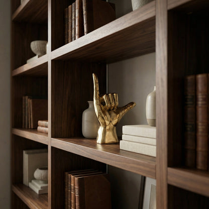 Noir Hawaiian Sculpture Antique Brass styled on a walnut bookshelf with ceramic vases and stacked books