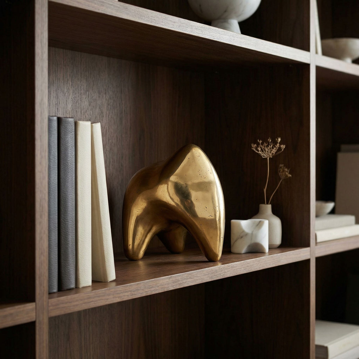 Noir Alien Sculpture Antique Brass styled in an interior setting