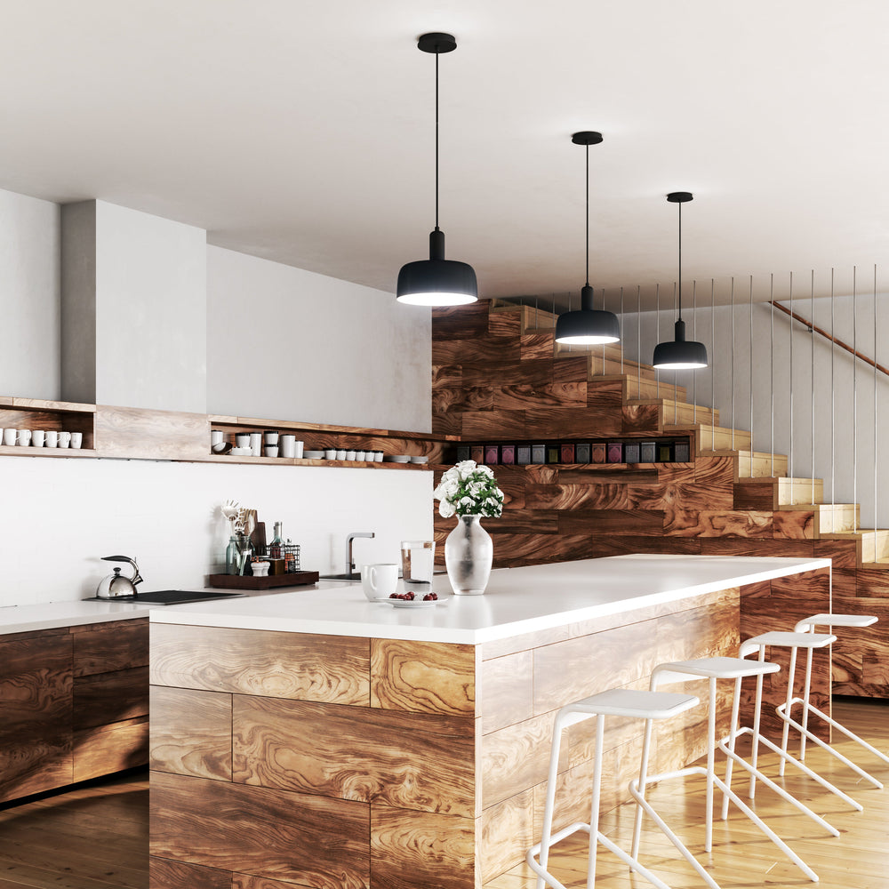 Modern kitchen with wooden island with three Adriano pendants styled above it and four white bar stools,