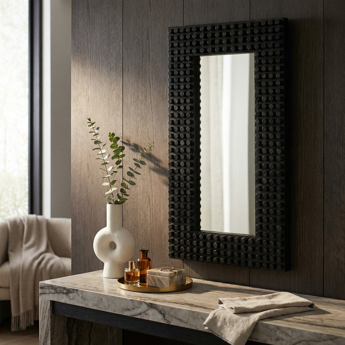 Noir Faustus Mirror Charcoal Black styled in an interior setting