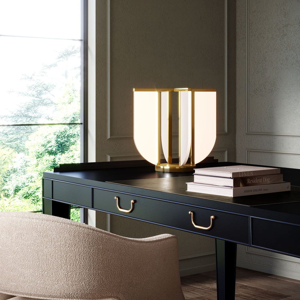 Modern desk with a stylish lamp and books in a office space with large windows.