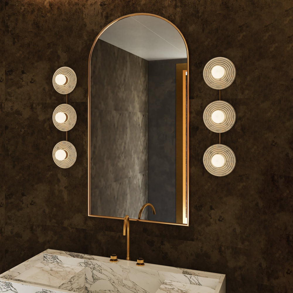 Bathroom vanity with a large mirror and wall-mounted lights on a dark textured wall.