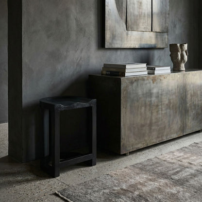 Noir Saddle Counter Stool Hand-Rubbed Black styled in an interior setting
