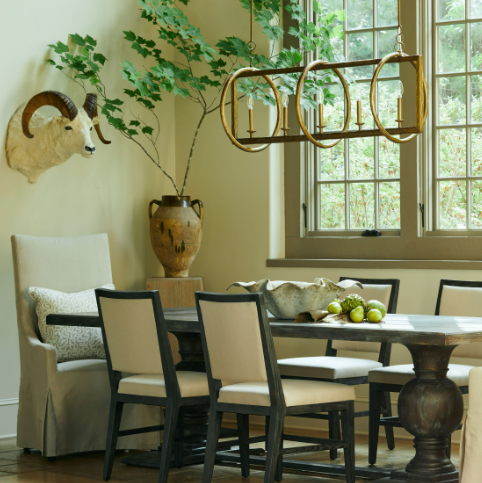 Farmhouse style dining room with a rustic chandelier, table, chairs, and decorative elements.