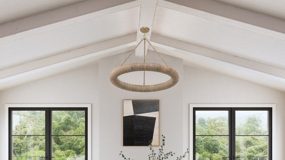Farmhouse style living room with white sofas, wooden chairs, circular chandelier and a coffee table.