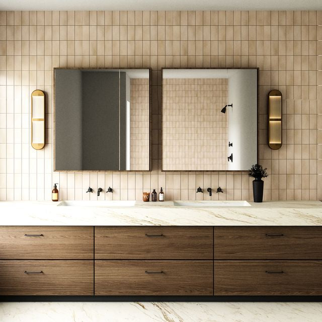 Modern bathroom with dark wooden vanity, marble countertop, wall sconces flanking each side of the vanity, and tiled walls.