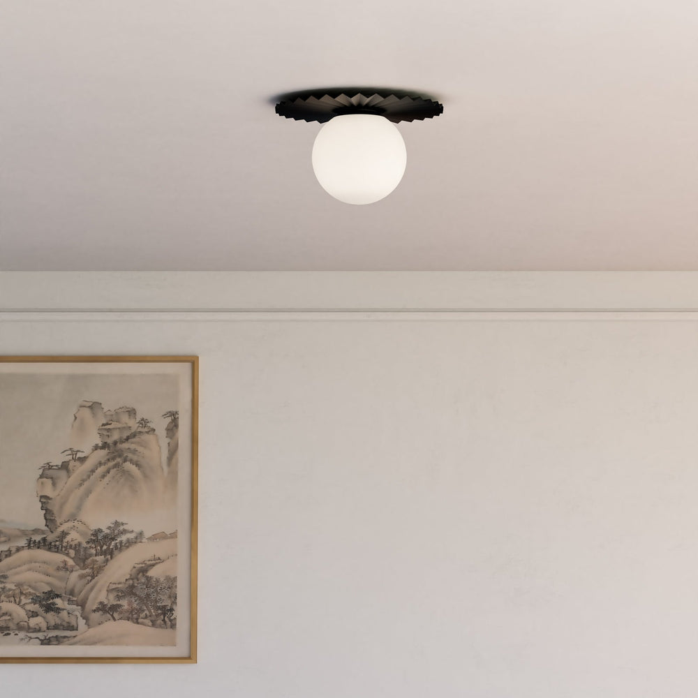 A vintage styled semi flush mount styled in a hallway with ivory paint and artwork on the wall. 