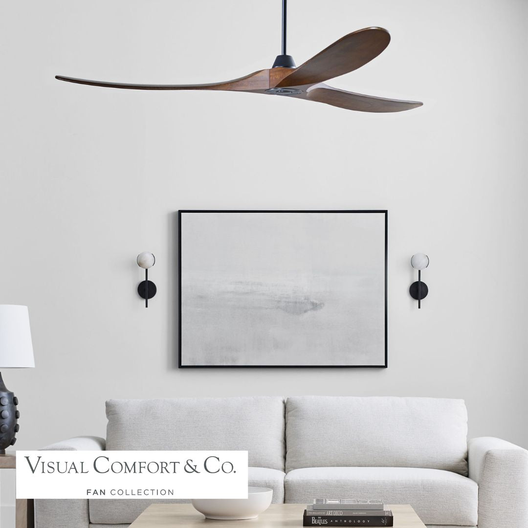 Modern living room with a ceiling fan, sofa, and wall art, featuring Visual Comfort & Co. branding.